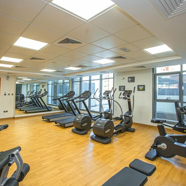 Spacious gym interior with minimal equipment and clean design.